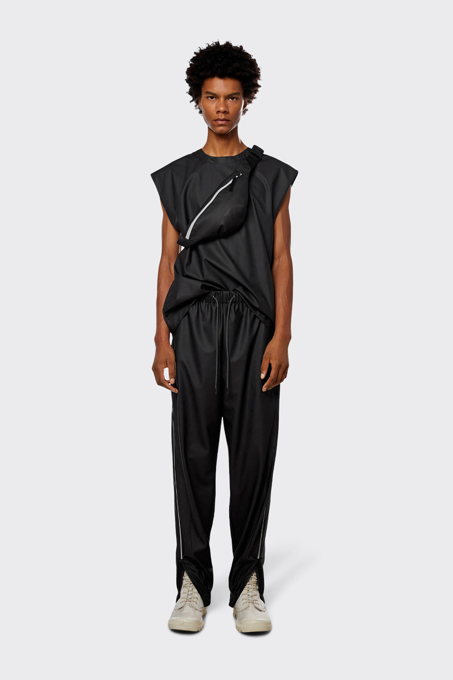 Men's waterproof lightweight track pants in black with reflective side stripe.